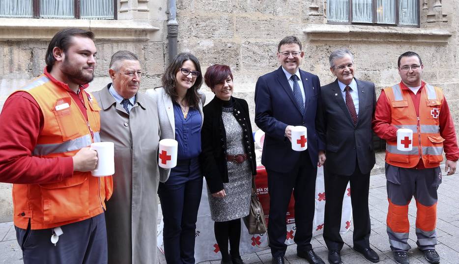 11-12-2015. Ximo Puig, acompañado de Oltra, se acercan a la mesa petitoria del día de la banderita.