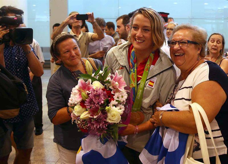 23/08/2016. La nadadora Mireia Belmonte, medalla de oro en 200 mariposa y bronce en 400 estilos, posa con dos vecinas de su localidad, a su llegada hoy al aeropuerto de El Prat, después de su participación en los Juegos Olímpicos de Río de Janerio (Foto: EFE)