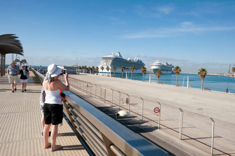 Un grupo de turistas fotografía tres cruceros amarrados en el Puerto de Alicante, en una escala múltiple.