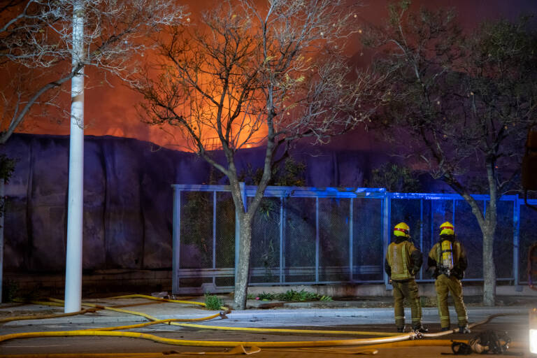 Bomberos apagando el incendio, este domingo, en la nave de Caster.